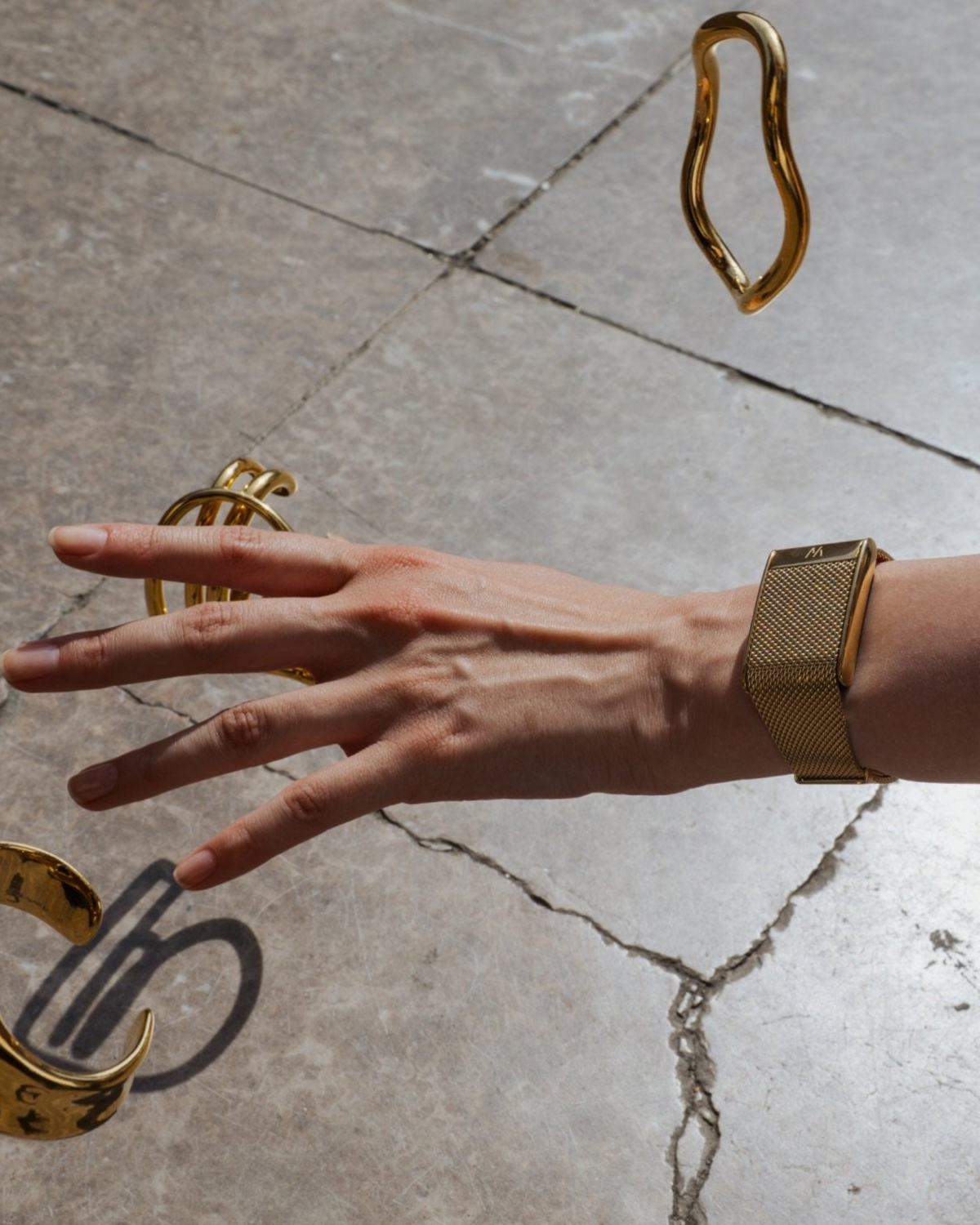 Close up of a woman's hand wearing Whoop 5.0 Meridian Band in Gold