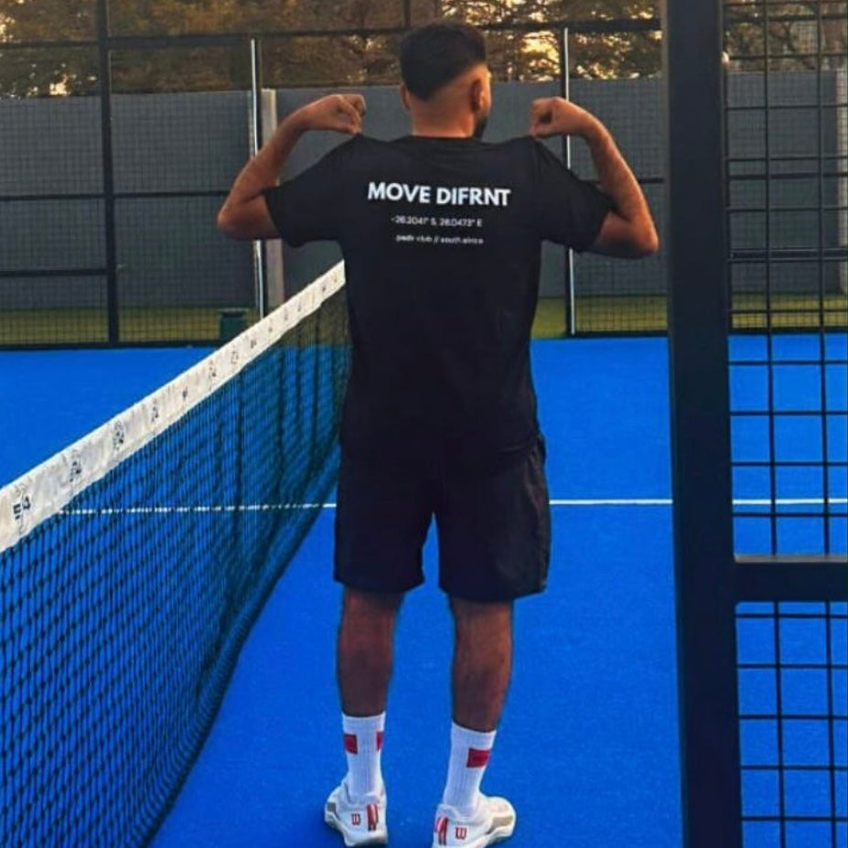 Customer wearing a black Move Difrnt tee on a blue padel court