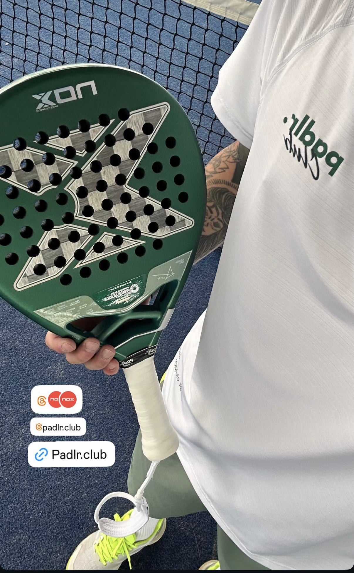 Community photograph of a player wearing a white Padlr Club tee beside a padel net