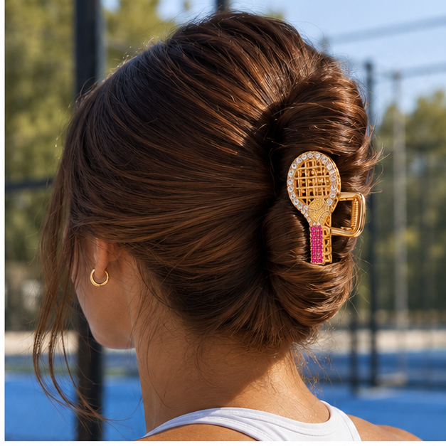 Woman wearing the gold racket claw clip in a French twist on a padel court